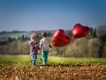 Children with balloons in a field