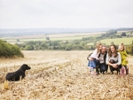 family in field with dog